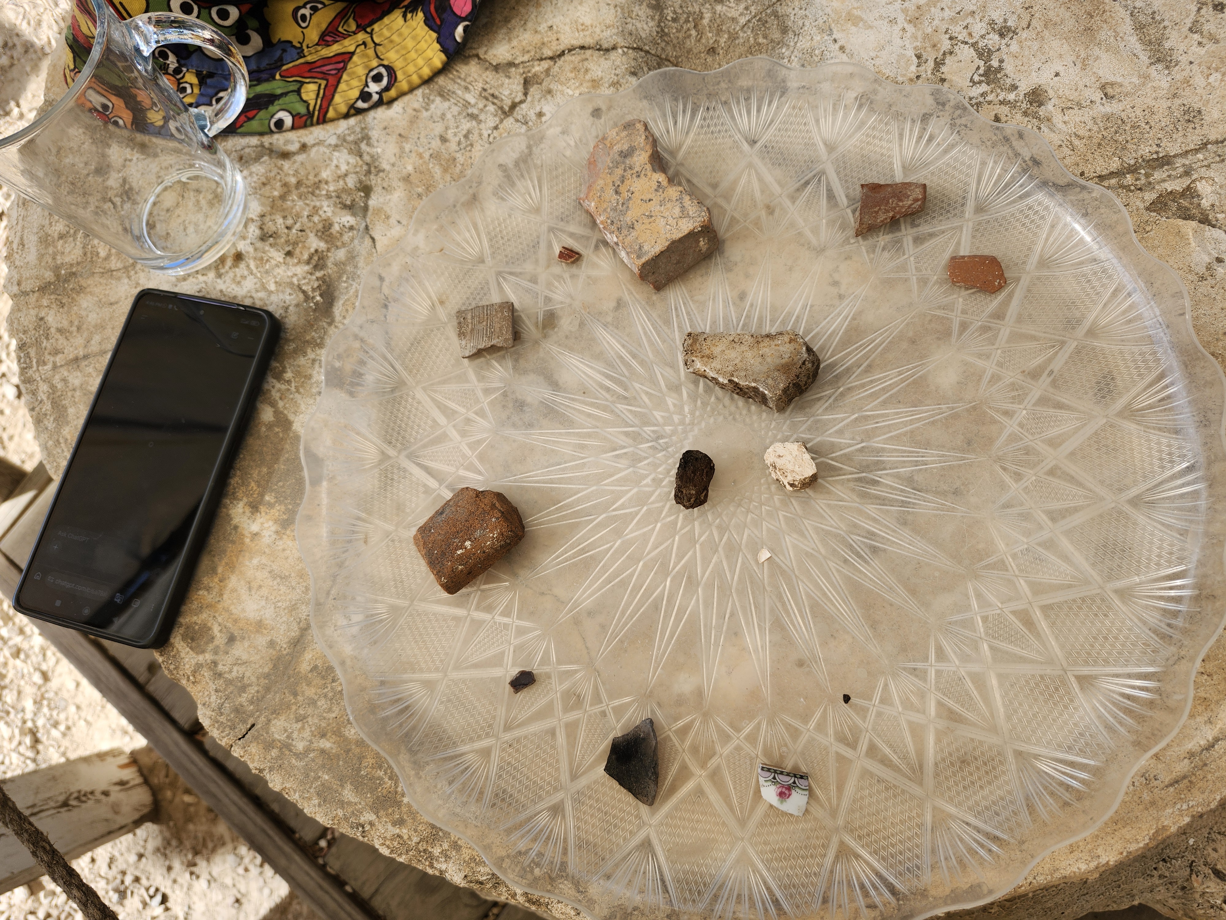 A sample of artifacts recovered during a day of wet sifting at the Temple Mount Sifting Project in Jerusalem, with a cellphone at left for scale. Photo by Dave Gordon.