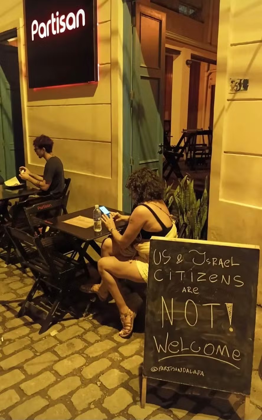 A sign displayed outside a bar in Rio de Janeiro, Brazil, reads: "US & Israel Citizens Are Not Welcome."