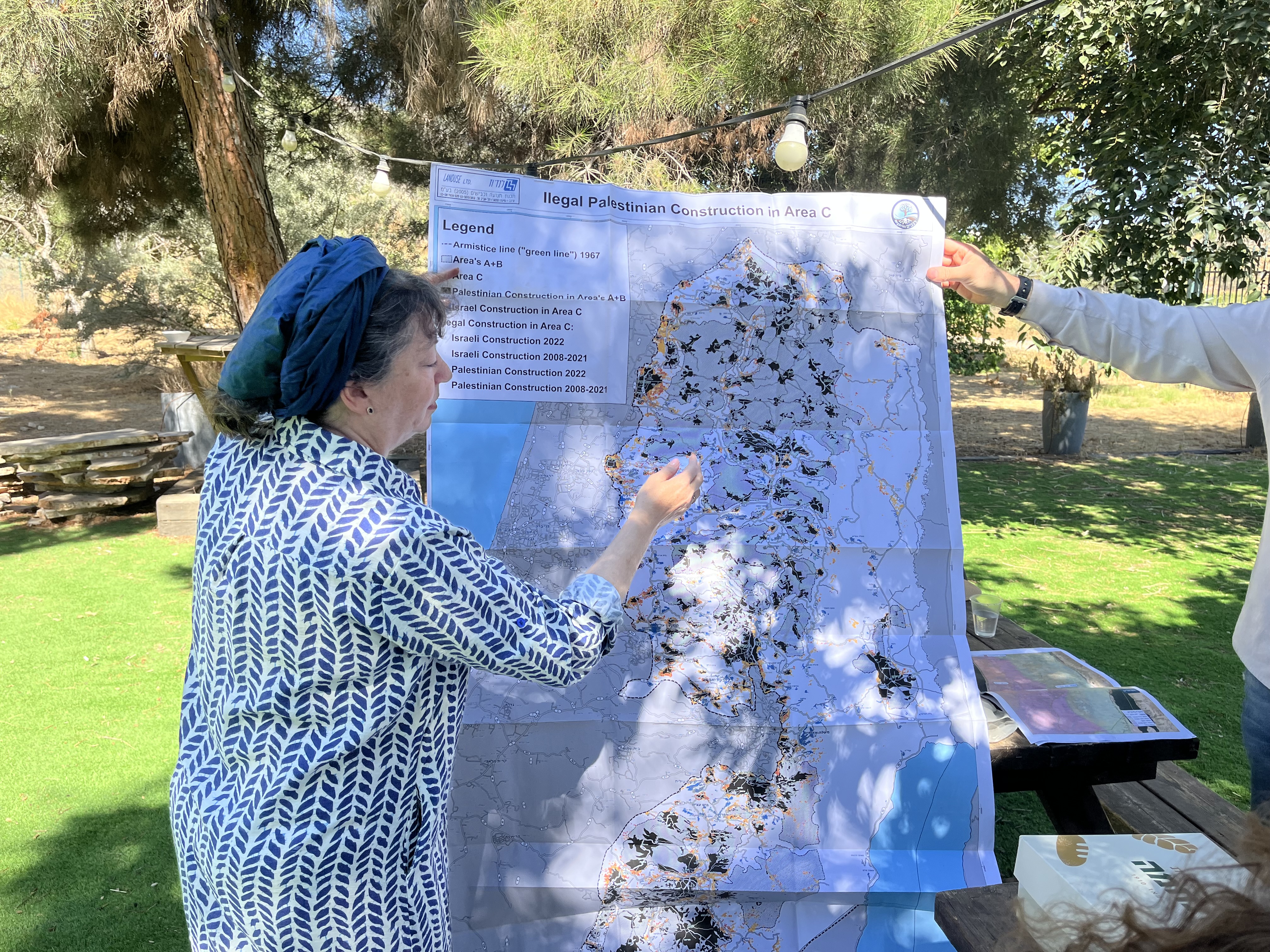 Naomi Kahn, director of Regavim’s International Division, points to illegal Palestinian Authority construction on a map during a tour in the southern Hebron Hills, July 14, 2026. Photo by Josh Hasten.