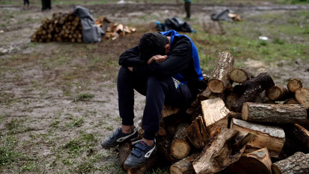 A young Syrian refugee takes a rest at a firewood distribution point at Idomeni refugee camp on May 3, 2016. Photo: Gili Yaari/Flash90
