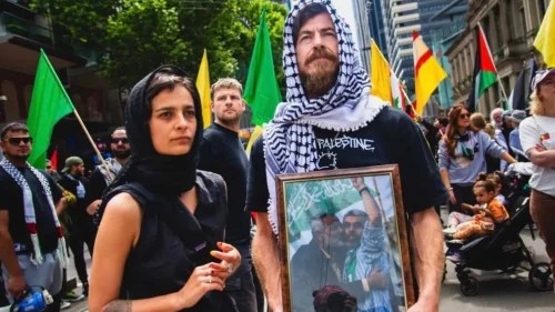 An activist poses with a portrait of Hamas terrorist leader Yahya Sinwar during an anti-Israel protest in Melbourne, Australia. Credit: Israel Police.