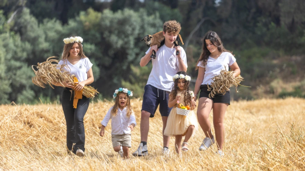 Young Israelis from Ben Shemen pose for a picture in a harvest field ahead of Shavuot, on May 18, 2023. Photo by Yossi Aloni/Flash90.