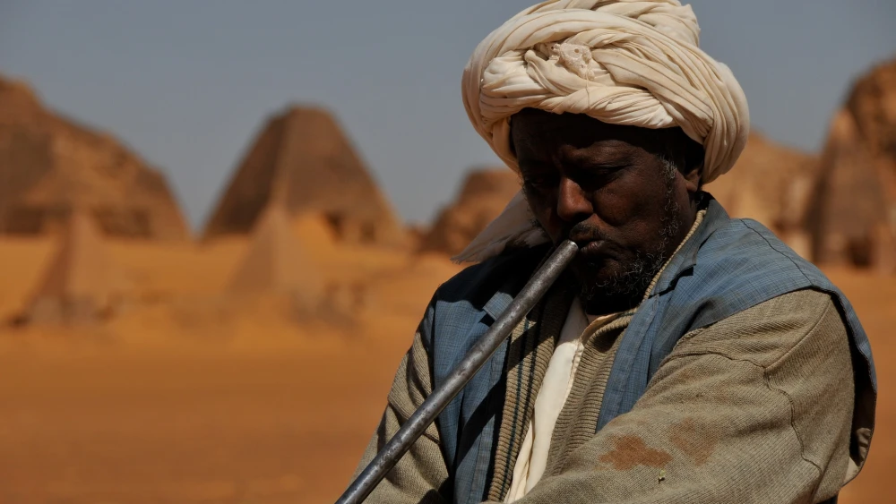 A man plays music in the desert in Sudan. Credit: mtorrazzina/Pixabay.