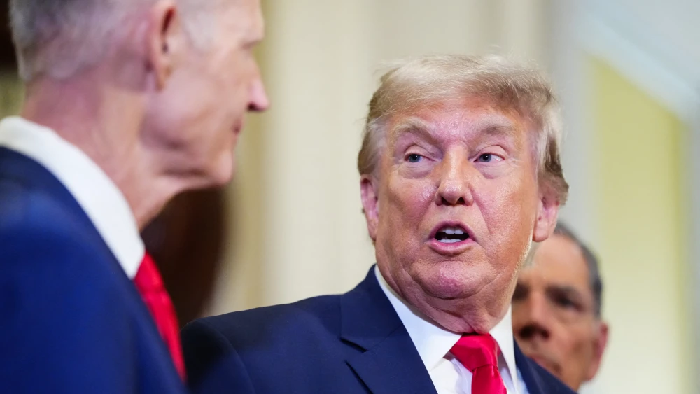 Sen. Rick Scott (R-Fla.) looks on as U.S. President Donald Trump speaks to the press after a lunch meeting with Senate Republicans at the U.S. Capitol in Washington, D.C., on June 24, 2026. Photo by Aaron Schwartz/AFP/Getty Images.