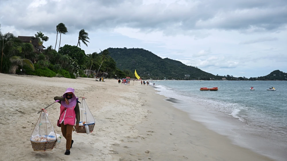 A vendor carries donuts on Lamai beach on the southern Thai island of Koh Samui