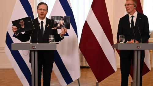 Israeli President Isaac Herzog holds up images of Israeli hostages Evyatar David and Rom Braslavski as Latvian President Edgars Rinkēvičs looks on during their joint press conference in Riga, Latvia, on Aug. 5, 2025. Photo: Haim Zach/GPO.