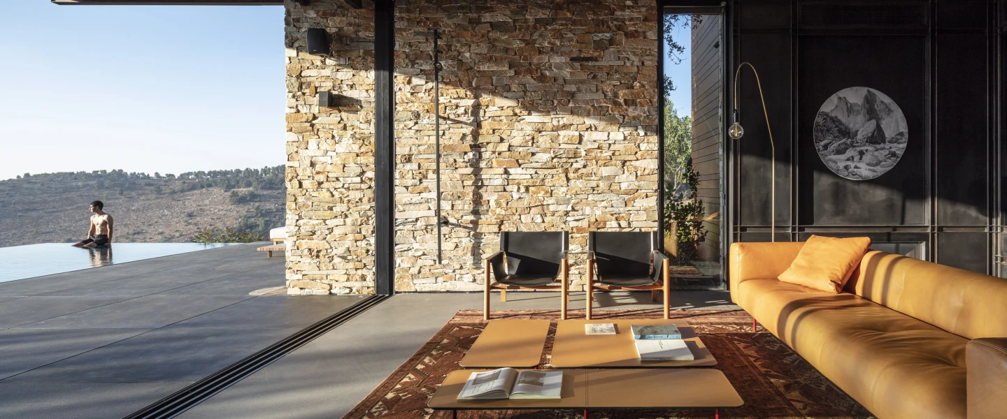 The contemporary stone villa in Neve Ilan designed by Dana Oberson is built on a sloping site overlooking the Judean Hills, with distant views toward the Mediterranean. Photo by Amit Geron.