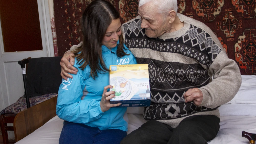 In Odessa, a volunteer distributes matzah to a local client. In addition to matzah distribution efforts across the former Soviet Union, JDC is also distributing 88 pounds of matzah to the Jewish community in Egypt. Credit: Courtesy.