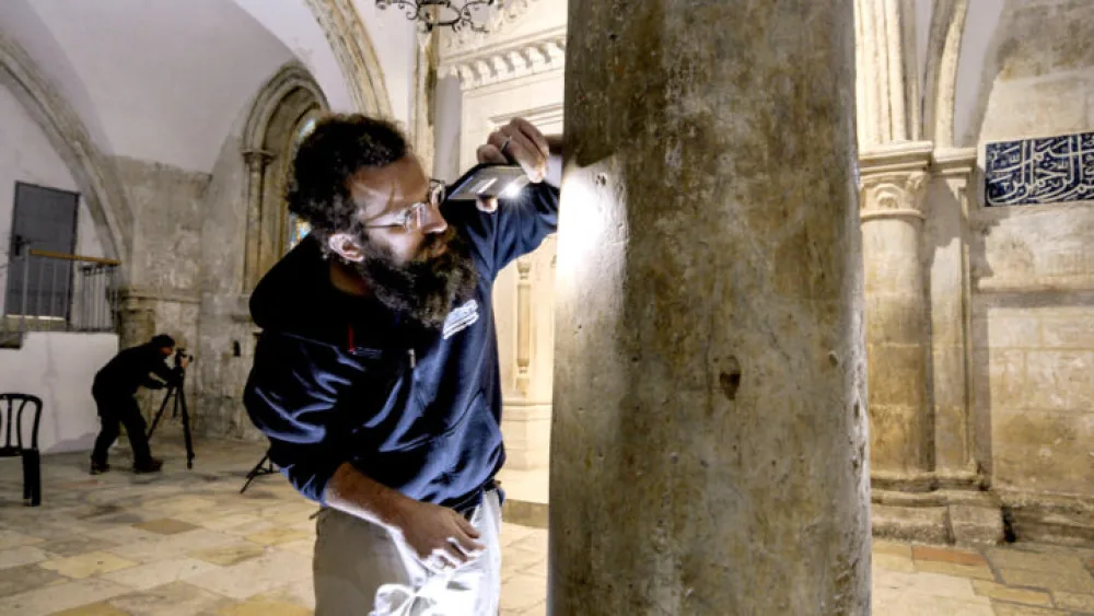 Israel Antiquities Authority researcher Michael Chernin documenting the pilgrims’ inscriptions on the walls of the complex. Photograph: Joshua Faudem.