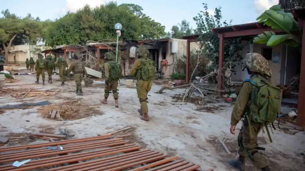 Israeli soldiers walk through the destruction caused by Hamas terrorists in Kibbutz Kfar Aza, Oct. 15, 2023. Photo by Edi Israel/Flash90.