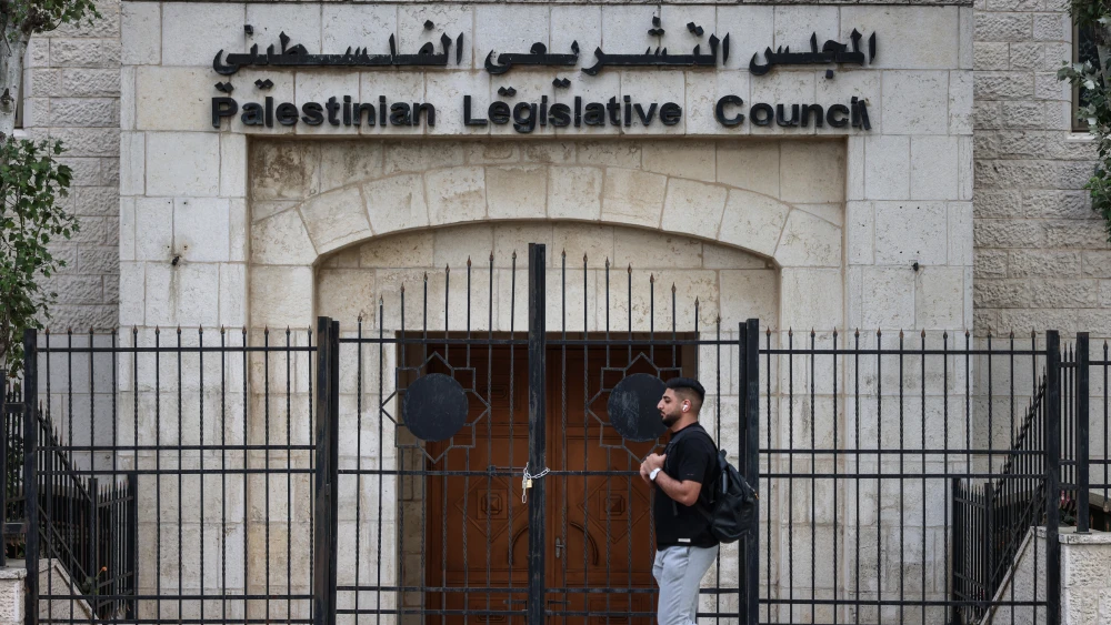 A pedestrian walks past the closed Palestinian Legislative Council building in Ramallah, Judea and Samaria, Oct. 11, 2026. Palestinian Authority chief Mahmoud Abbas announced the postponement of elections to September 2027. Photo by Zain Jaafar/AFP via Getty Images.