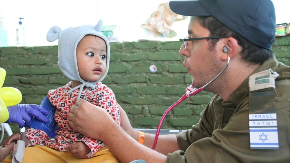 An IDF officer treats a child in Nepal in 2015. Credit: IDF.