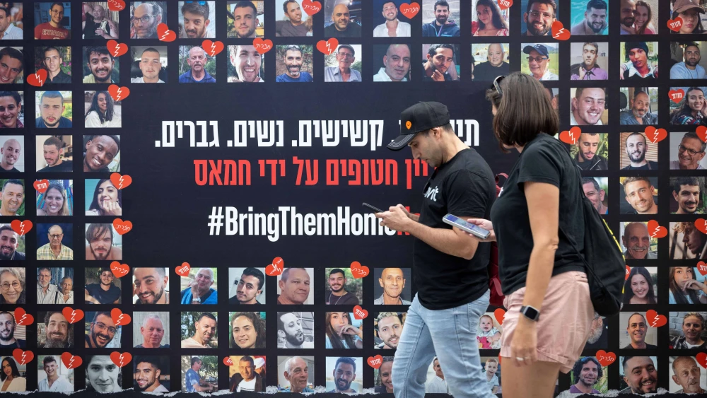 People walk past posters of Israelis who have been and are still held hostage by Hamas, in Tel Aviv. May 21, 2025. Photo by Miriam Alster/Flash90.