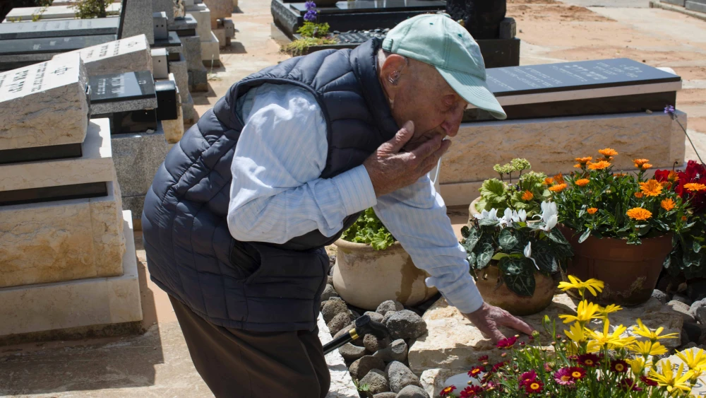 Yaakov Lubinewski, 99, tends the graves of two Israeli soldiers from his town killed during Hamas's Oct. 7 massacre, March 26, 2024. Credit: Rina Castelnuovo.