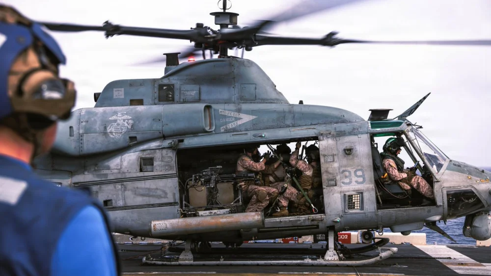 U.S. Marines with the 31st Marine Expeditionary Unit load onto a UH-1Y Venom aboard USS Tripoli (LHA 7) to conduct aerial sniper and close air support training while transiting regional waters in June 2026. Credit: U.S. Central Command.