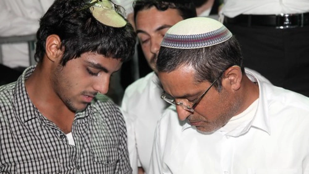 Ouria Yifrach (right), father of missing Israeli teenager Eyal Yifrach, and Eyal's brother, Assaf, pray alongside hundreds for the safety of three missing Israeli teens, June 14, 2014. Credit: Gideon Markowicz/Flash90.