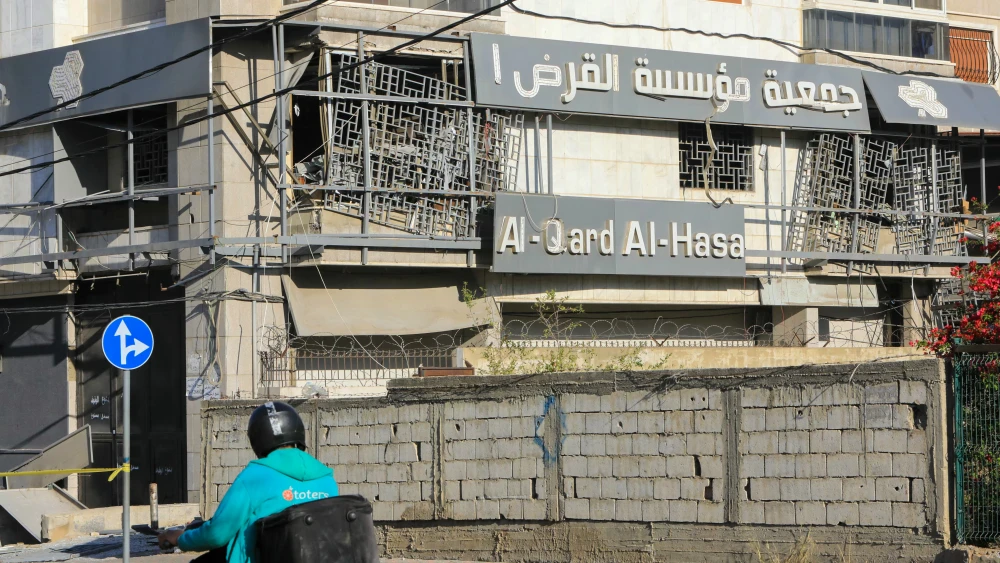 A man rides a moped past a branch of the Al-Qard Al-Hassan finance group hit by an Israeli airstrike in Beirut’s southern suburbs, Oct. 21, 2024. Credit: AFP via Getty Images.