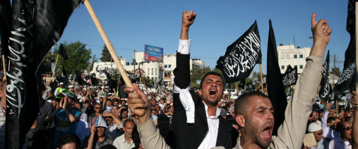 Palestinian supporters of Hizb ut-Tahrir, or the Islamic Liberation Party, chant slogans and wave black and white flags reading "There is no God but God, and Muhammad is his prophet" during a rally in Ramallah on July 7, 2012. Photo by Issam Rimawi/Flash90.