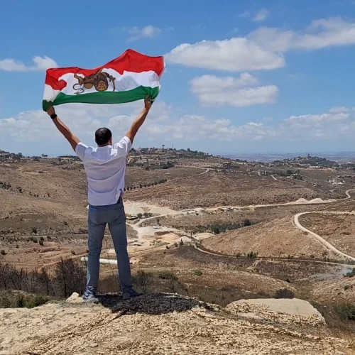 Ahmad Batebi, an Iranian non-Jewish activist and journalist waving the “Sun and Lion” Iranian flag that was used during the Pahlavi dynasty, in Israel. Credit: Courtesy.