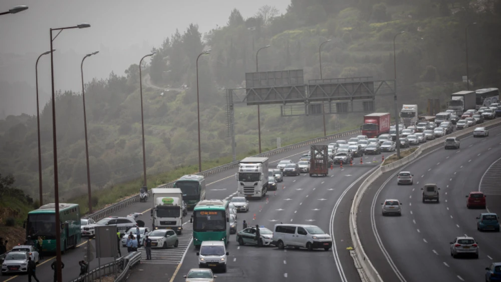 Israeli police officers pull over a bus on Highway 1 near Jerusalem to arrest a man that earlier tested positive for coronavirus, on April 5, 2020. Photo by Yonatan Sindel/Flash90.