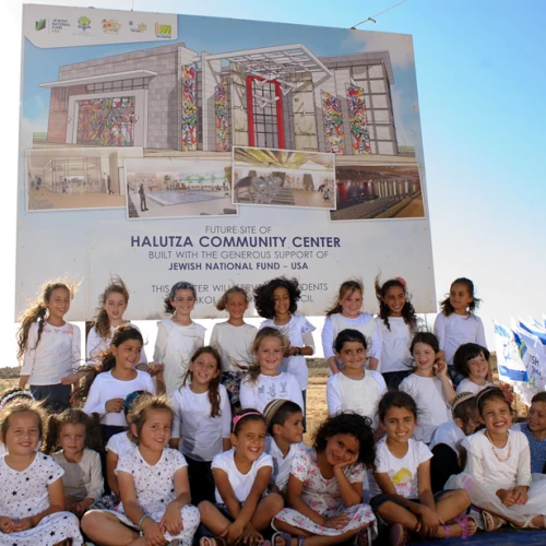 Children of Halutza sit in front of the site of the new state-of-the-art Halutza Community Center. Credit: Jewish National Fund-USA.