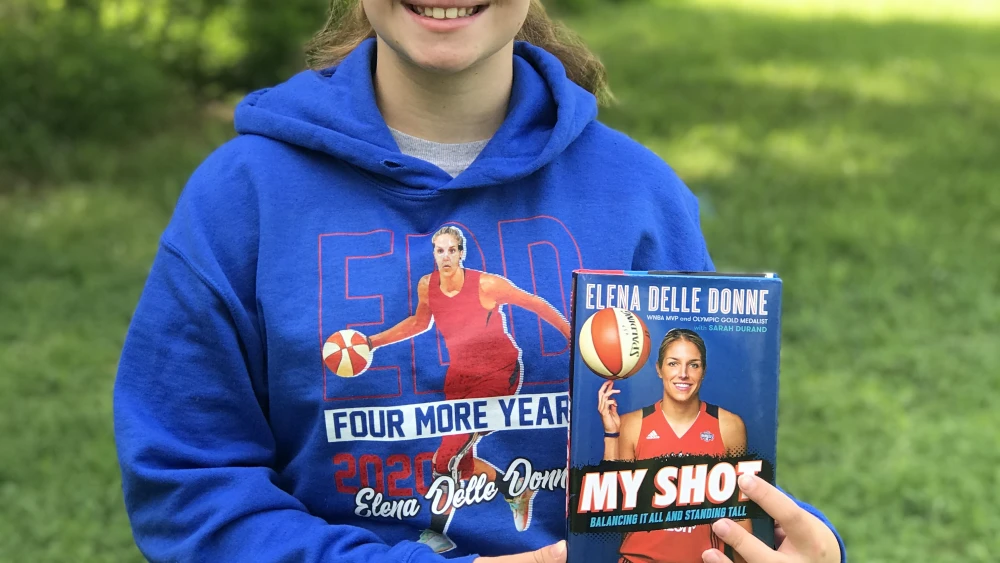 Adi Topolosky posing with a book by WNBA basketball player Elena Delle Donne, who plays for the Washington Mystics in Washington, D.C. Credit: Courtesy.