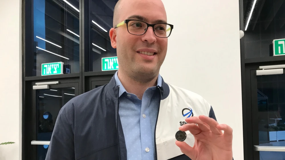 SpaceIL co-founder Yonatan Winetraub displaying a copy of the coin-size nano Bible in the time capsule aboard “Beresheet.” Photo by Abigail Klein Leichman