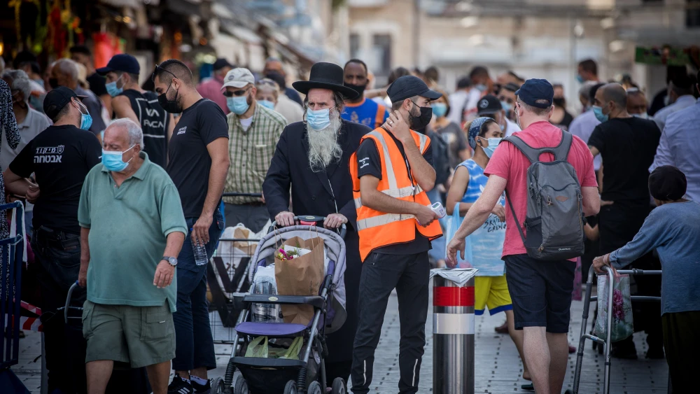 People wear face masks shop at the Machane Yehuda Market in Jerusalem on the eve of the Jewish new year, on Sept. 18, 2020. Photo by Yonatan Sindel/Flash90.