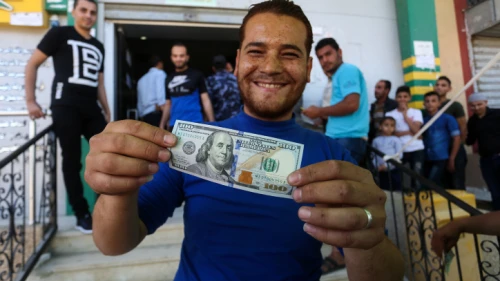 Palestinians receive cash as part of $480 million in aid allocated by Qatar, at a post office in Gaza City on May 19, 2019. Photo by Abed Rahim Khatib/Flash90.