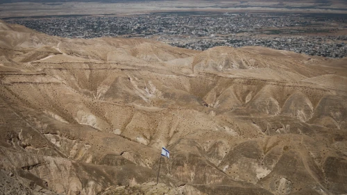 An Israeli flag with a view of the Jordan Valley on June 14, 2020. Photo by Yonatan Sindel/Flash90.