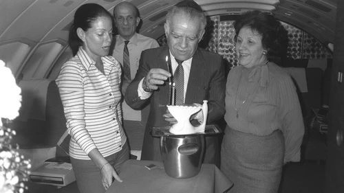 Former Israeli Prime Minister Yitzhak Shamir flanked by his wife, Shulamit, and a hostess lighting Hanukkah candles on their return flight from Washington, on Feb. 12,1983. Credit: GPO.