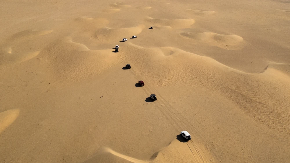 An aerial image shows cars driving along the dunes in the Samawah desert in southern Iraq, Nov. 22, 2025. Photo by Hussein Faleh/AFP via Getty Images.