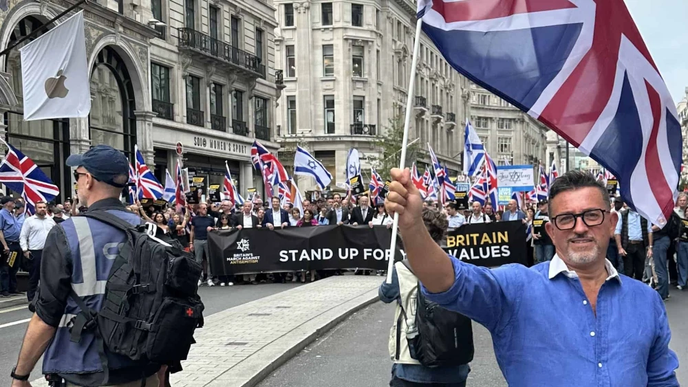 Lance Forman, a Jewish businessman from London and a former member of the European Parliament, waves a British flag at the Campaign Against Antisemitism's march in London on Sept. 7, 2025. Credit: Courtesy of Lance Forman.
