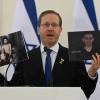 Israeli President Isaac Herzog holds pictures of hostages Evyatar David (left) and Rom Braslavski during a press conference in Vilnius, Lithuania, Aug. 4, 2025. Photo by Haim Zach/GPO.