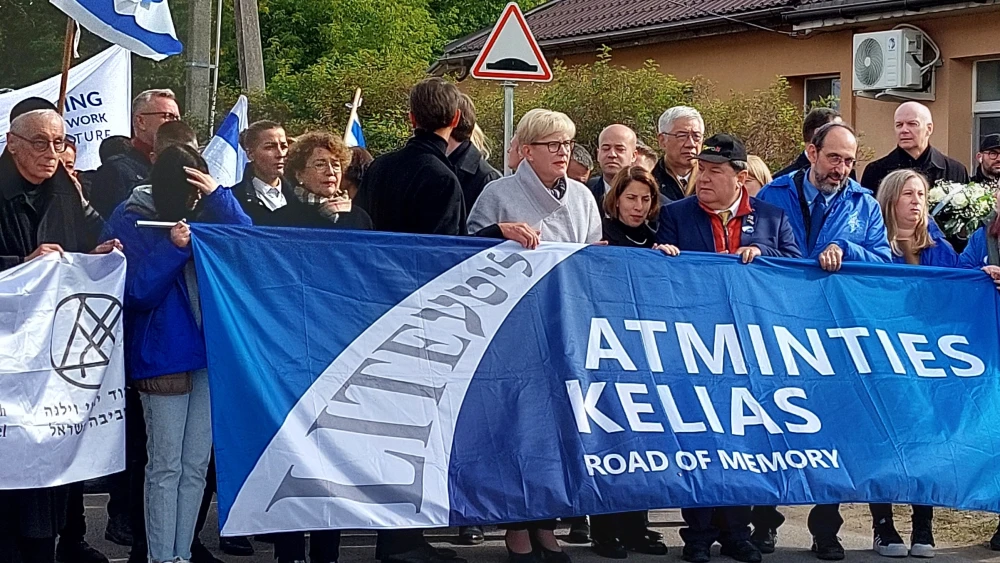Lithuanian Prime Minister Ingrida Simonyte (center) holding banner.