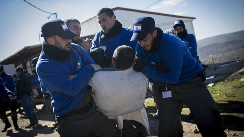 Israeli police forces carry out the evacuation of Amona as a resident resists the court-ordered process Feb. 2. Credit: Yonatan Sindel/Flash90.