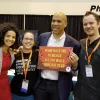 U.S. Sen. Cory Booker (D-N.J.) holds a sign reading: “From Palestine to Mexico, all the walls have got to go.” Credit: Twitter via U.S. Campaign for Palestinian Rights.