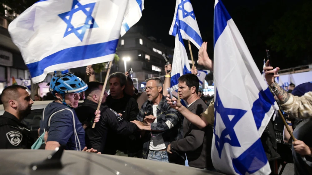 Police officers stand guard while Israelis demonstrate against Prime Minister Benjamin Netanyahu's wife, Sara Netanyahu, outside a hair salon in Tel Aviv, March 1, 2023. Photo by Avshalom Sassoni/Flash90.