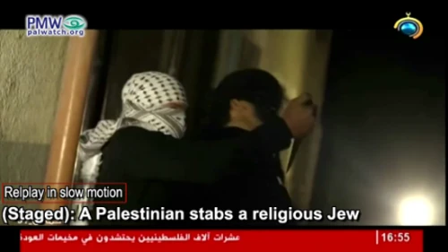 In this image from a video posted online by Hamas TV on May 15, 2019, a masked Palestinian terrorist is shown stabbing a religious Jew. Credit: Screenshot via PMW.