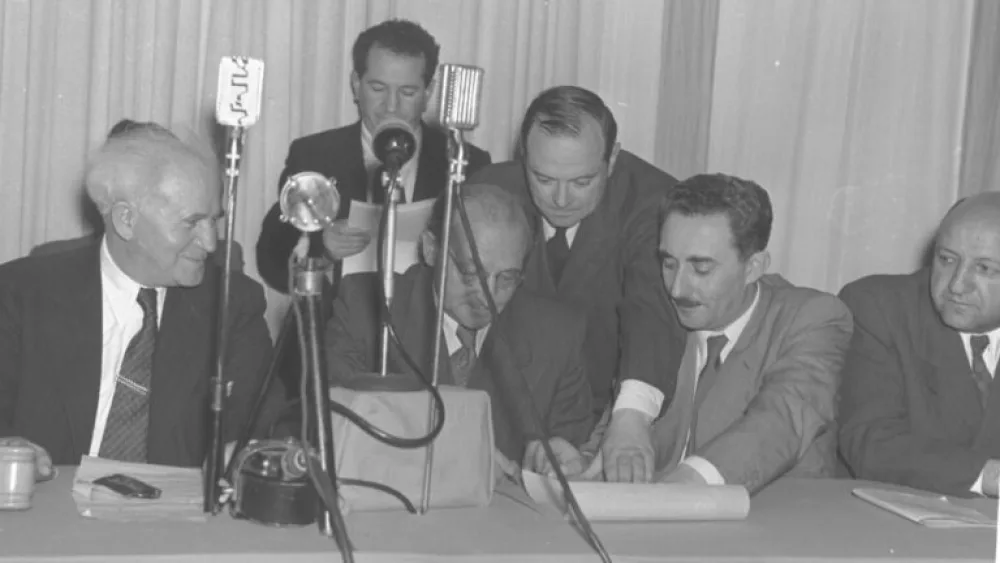 Israel’s leaders sign an empty piece of parchment that will later be sewn into the text of the Declaration of Independence. Photo by Frank Shershel/Government Press Office.