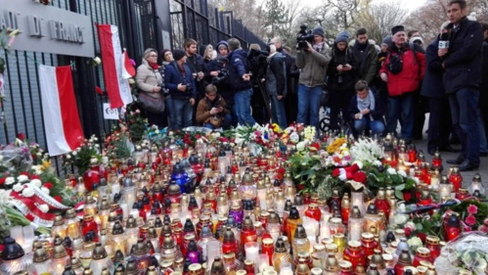 Candles and flowers for the victims of the Nov. 13 Paris attacks outside of the French Embassy in Warsaw. Credit: Halibutt via Wikimedia Commons.