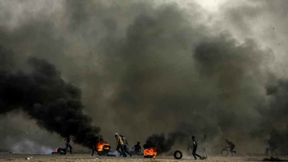 Palestinian demonstrators burn tires as part of a violent demonstration on the Gaza-Israel border that turned deadly on Oct. 12, 2018, when a Gaza exploded a bomb and infiltrated the security fence in the attempt to attack Israeli soldiers. Photo by Abed Rahim Khatib/Flash90.