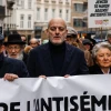 Joël Rubinfeld, president of the Belgian League Against Antisemitism, center, and Regine Sluszny, president of the Forum of Jewish Organizations of Belgium’s Flemish Region, carry a banner as they take part in a march against Antisemitism in Brussels, Belgium on Dec. 10, 2023. Photo by SIMON WOHLFAHRT/AFP via Getty Images.