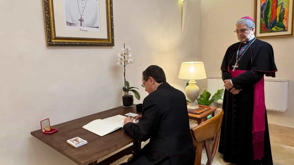 Israeli President Isaac Herzog signs the book of condolences at the Vatican's embassy in Tel Aviv as Apostolic Nuncio Adolfo Tito Camacho Yllana watches, May 2, 2025. Credit: President's Spokesperson.