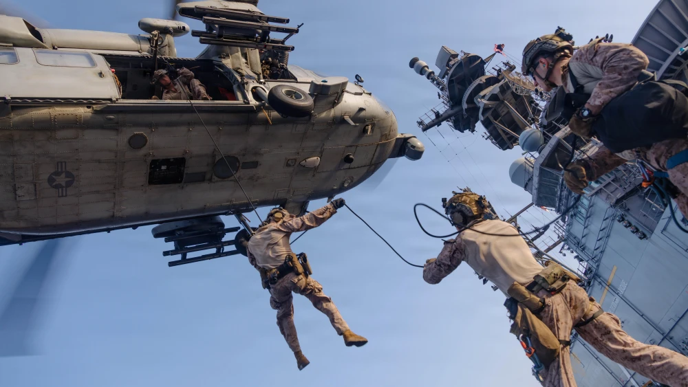 U.S. Marines with Maritime Raid Force, 31st Marine Expeditionary Unit, rappel out of an MH-60S Sea Hawk, assigned to Helicopter Sea Combat (HSC) Squadron 25, during helicopter and roping sustainment training aboard the forward-deployed amphibious assault ship USS Tripoli (LHA 7) in the U.S. Central Command area of responsibility, May 8, 2026. U.S. Marine Corps photo.