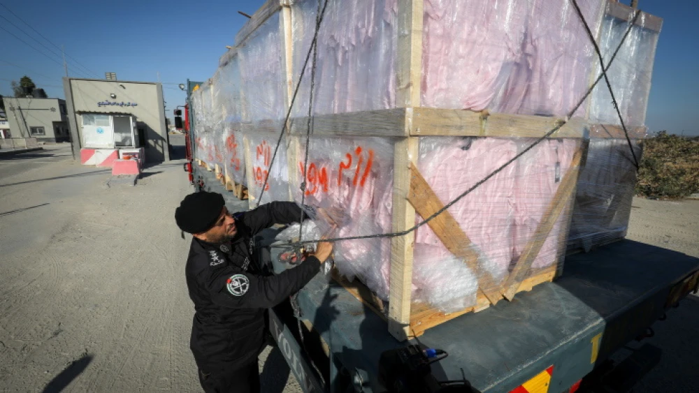 A Palestinian policeman inspects a truckload of textiles at the Kerem Shalom crossing in the Gaza Strip, June 21, 2021. Photo by Abed Rahim Khatib/Flash90.