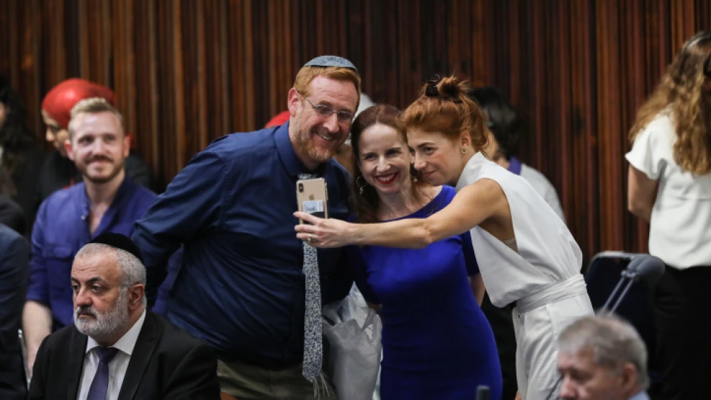 Knesset members Yehuda Glick and Stav Shafir, and actress Maya Wertheimer, pose for a selfie at the plenary hall during the swearing-in ceremony of MKs as a new session opens following the elections on April 30, 2019. Photo by Noam Revkin Fenton/Flash90.