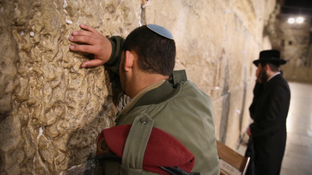 An Israeli soldier and ultra-Orthodox Jewish man pray at the Western Wall, Judaism's holiest site, in Jerusalem's Old City, March 14, 2019. Photo by David Cohen/Flash90.
