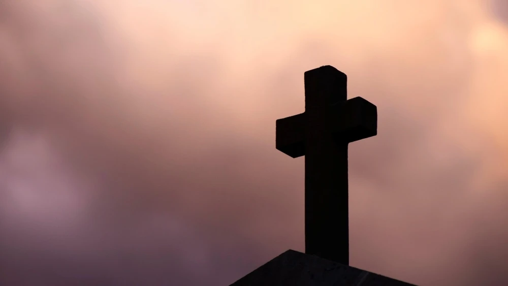 A stone cross in shadow. Credit: Mirosław i Joanna Bucholc/Pixabay.