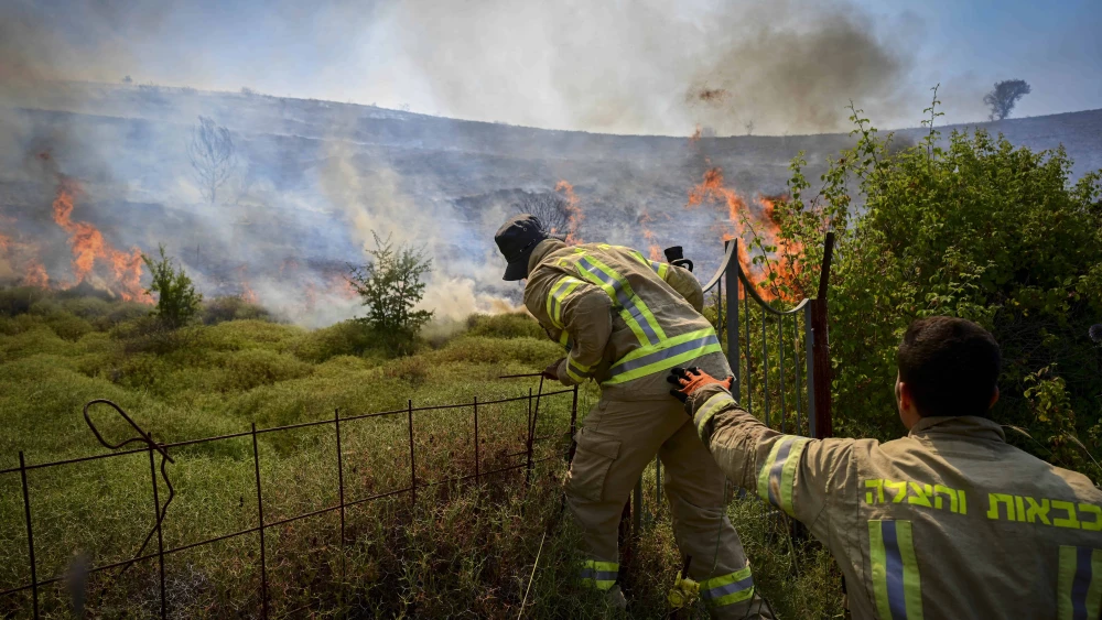 Israeli firefighters try to extinguish a fire sparked by missiles launched from Lebanon, near the northern city of Safed, June 12, 2024. Photo by Michael Giladi/Flash90.